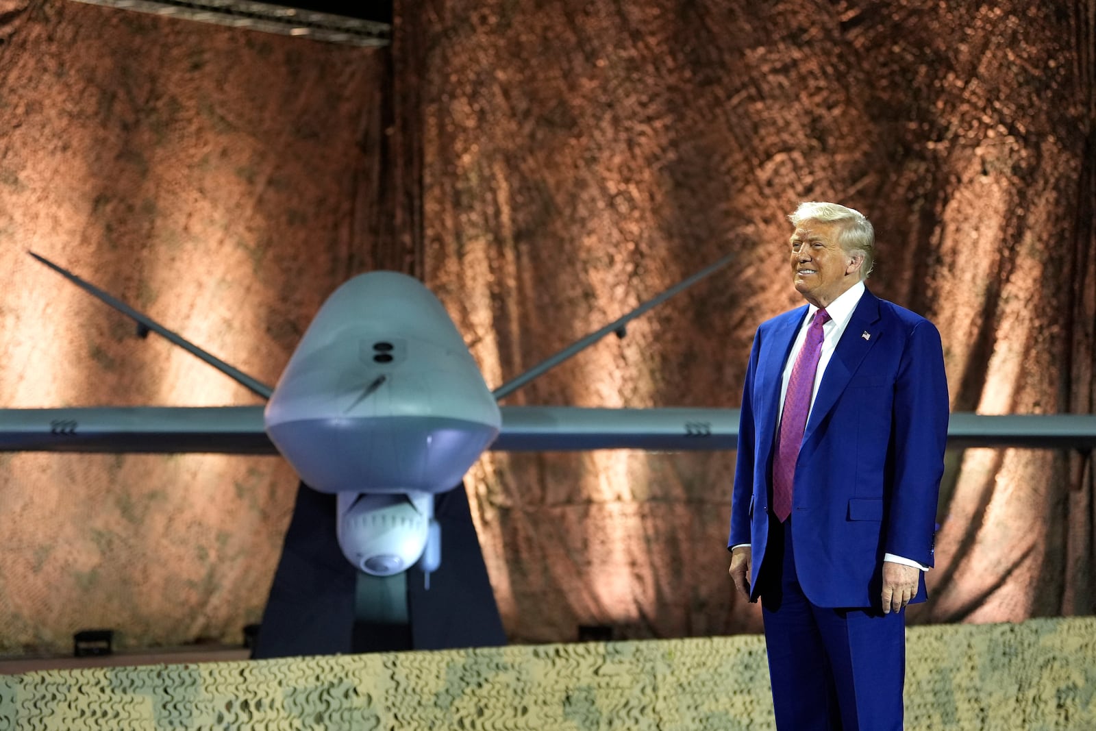 President Donald Trump stands backdropped by an MQ-9 Reaper drone before addressing military personnel at the Al Udeid Air Base, Thursday, May 15, 2025, in Doha, Qatar. (AP Photo/Alex Brandon)