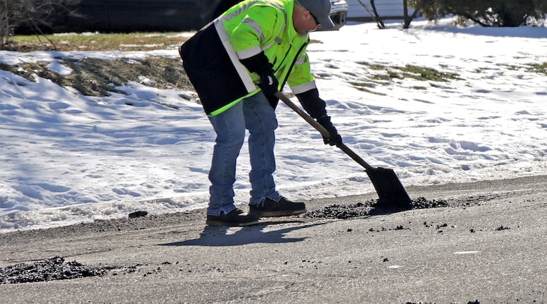 Tait Schnitzler, an employee of the City of Springfield, patches a pot hole along Superior Avenue Tuesday, Jan. 28, 2025. STAFF