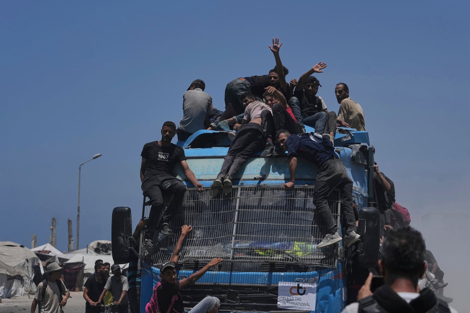 Palestinians hold onto an aid truck returning to Gaza City from the northern Gaza Strip on Tuesday, July 22, 2025. (AP Photo/Jehad Alshrafi)