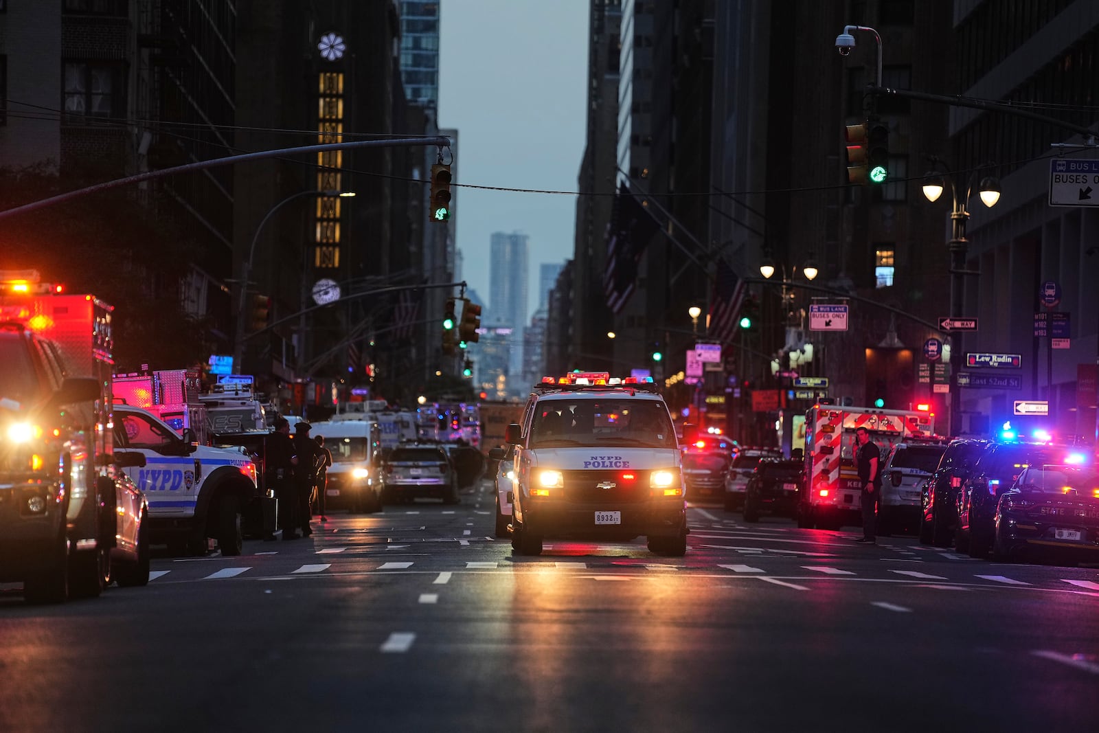 Emergency response vehicles crowd 52nd Street outside a Manhattan office building where two people were shot, including a New York police officer, Monday, July 28, 2025, in New York. (AP Photo/Angelina Katsanis)