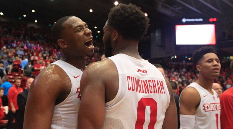 Dayton's Kendall Pollard and Josh Cunningham celebrate a victory over Virginia Commonwealth on March 1, 2017, at UD Arena.