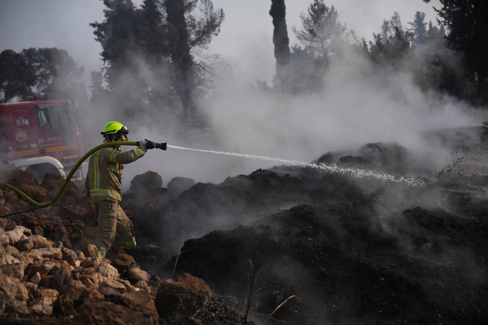An Israeli firefighter battles a wildfire near Latrun, Israel, outside of Jerusalem, Thursday, May 1, 2025. (AP Photo/Ohad Zwigenberg)
