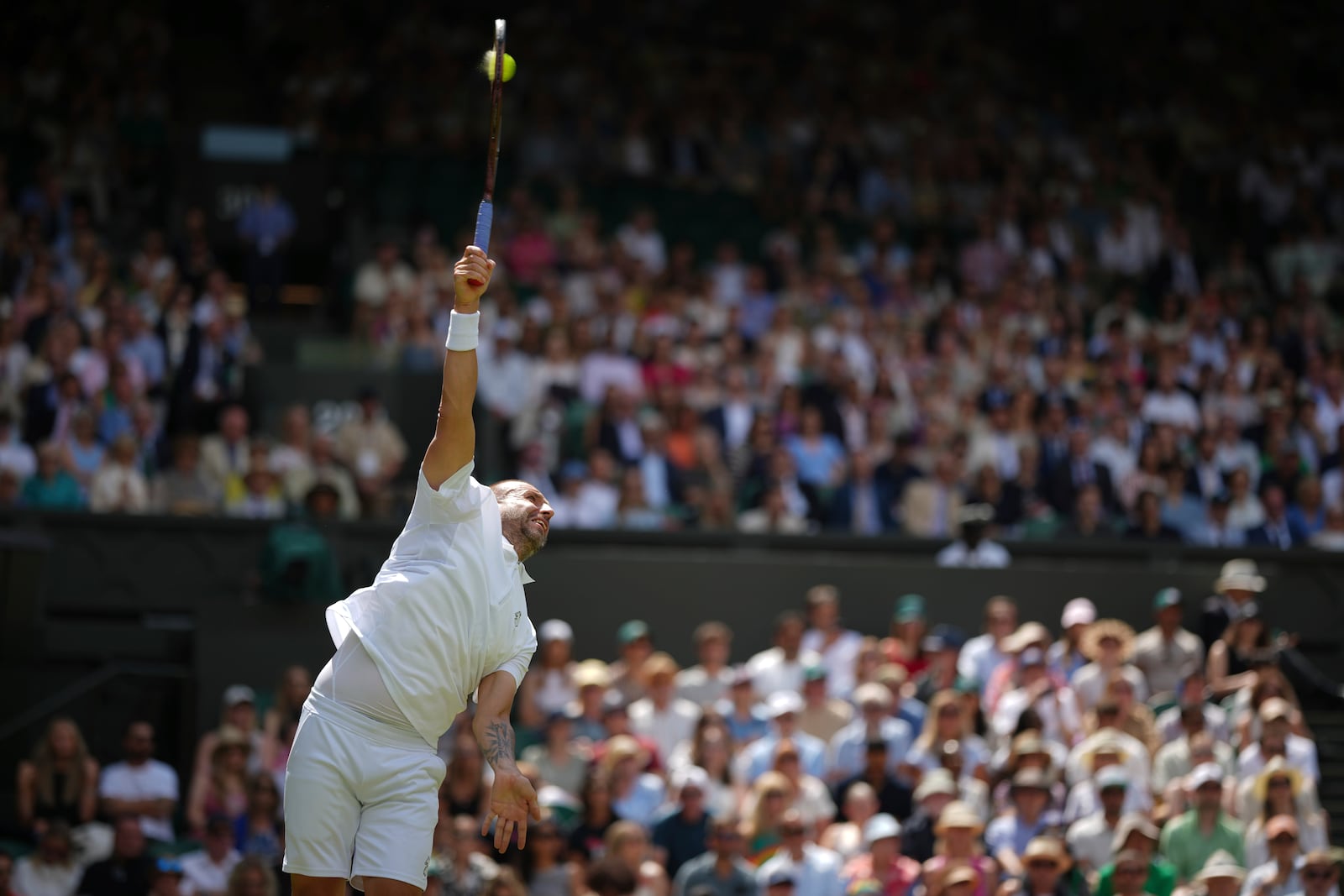 Daniel Evans of Britain serves to Novak Djokovic of Serbia during their second round men's singles match at the Wimbledon Tennis Championships in London, Thursday, July 3, 2025. (AP Photo/Alastair Grant)