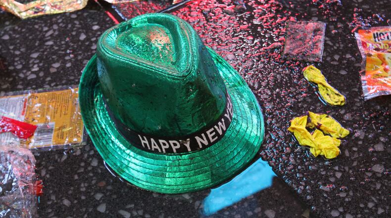 FILE - In this Jan. 1, 2019, file photo a "Happy New Year" hat lies on the wet ground along with other items following the celebration in New York's Times Square. Setting a New Year’s resolution about improving your finances is an excellent way to start 2021. But before you come up with a list of goals, be aware that there are a few you should avoid.  (AP Photo/Tina Fineberg, File)