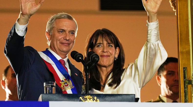 Chile's President Jose Antonio Kast and his wife Maria Pia Adriasola wave to supporters from the balcony of La Moneda presidential palace after his inauguration in Santiago, Chile, Wednesday, March 11, 2026. (AP Photo/Esteban Felix)