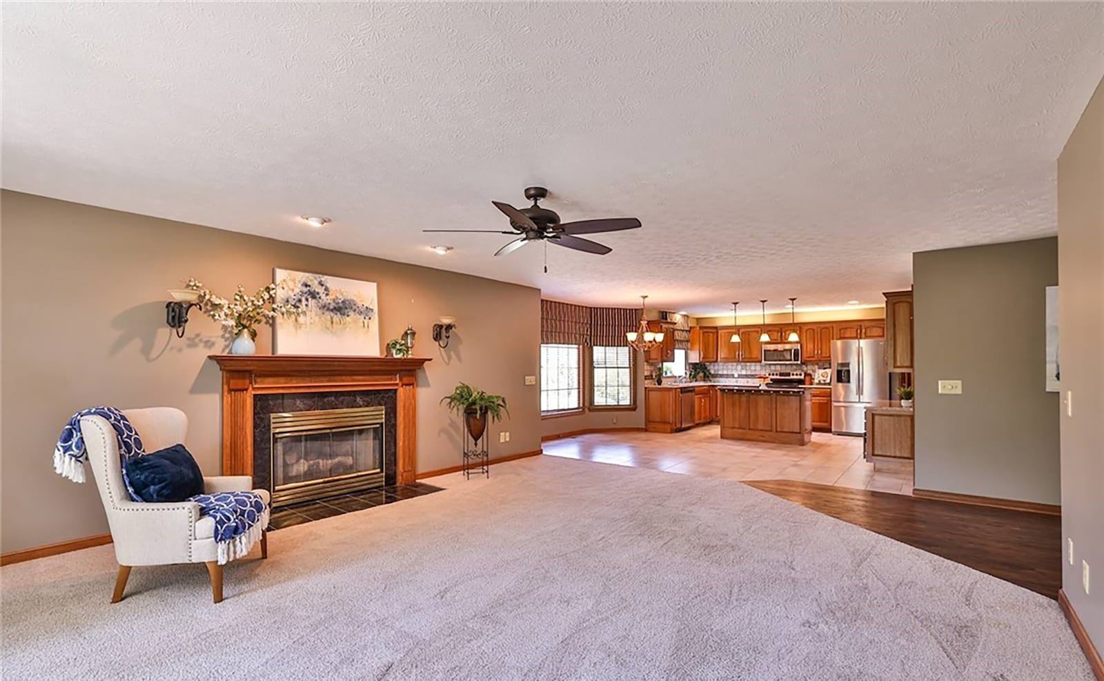 The family room has neutral carpeting, a ceiling fan, recessed lighting and a fireplace. It is open to the eat in kitchen. CONTRIBUTED