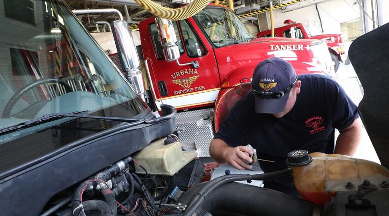 Urbana fire fighter Mike Drake checks the fluid level on a medic unit that has been causing problems Friday. The Urbana levy will mainly help keep staffing levels adequate but will also free up revenue for needed repairs. BILL LACKEY/STAFF