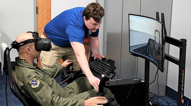 Matt Murdock, a Simulators Division contractor, assists Col. Cameron Dadgar, Nevada Test and Training Range commander, during a demonstration of a virtual reality flight simulator in the new Sims Holodeck. (US Air Force photo by Daryl Mayer)