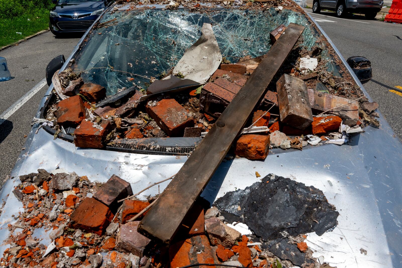 A damaged vehicle remains nearby in the Nicetown area of Philadelphia, Sunday, Jun. 29, 2025, where there were fatalities after three row houses collapsed after a fire and explosion. (Tom Gralish/The Philadelphia Inquirer via AP)