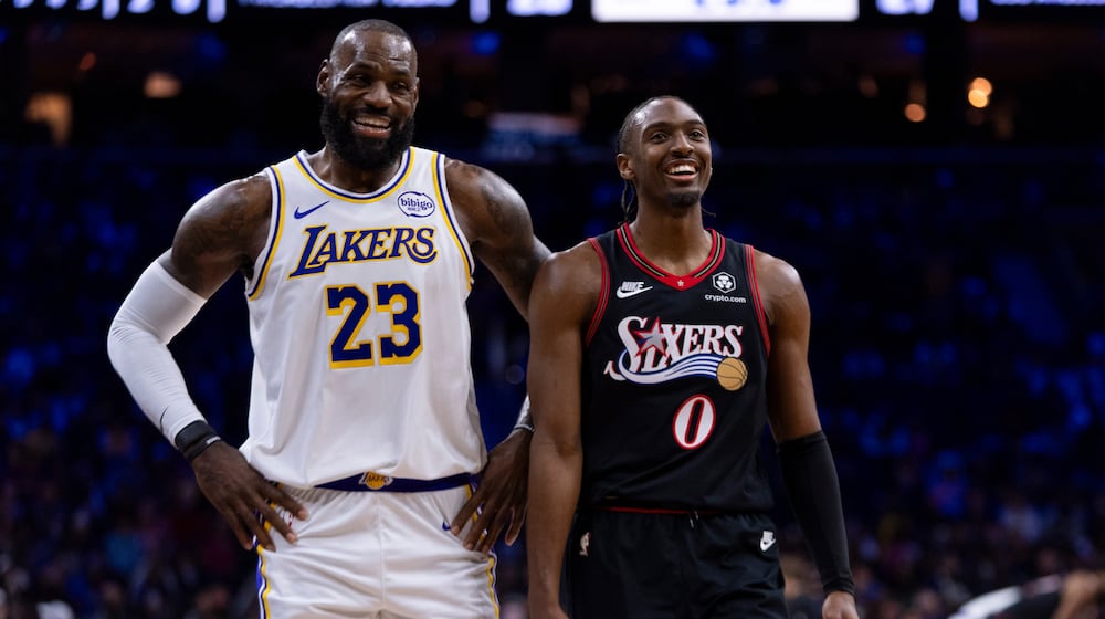 Los Angeles Lakers' LeBron James, left, talks with Philadelphia 76ers' Tyrese Maxey, right, during the first half of an NBA basketball game, Sunday, Dec. 7, 2025, in Philadelphia. (AP Photo/Chris Szagola)