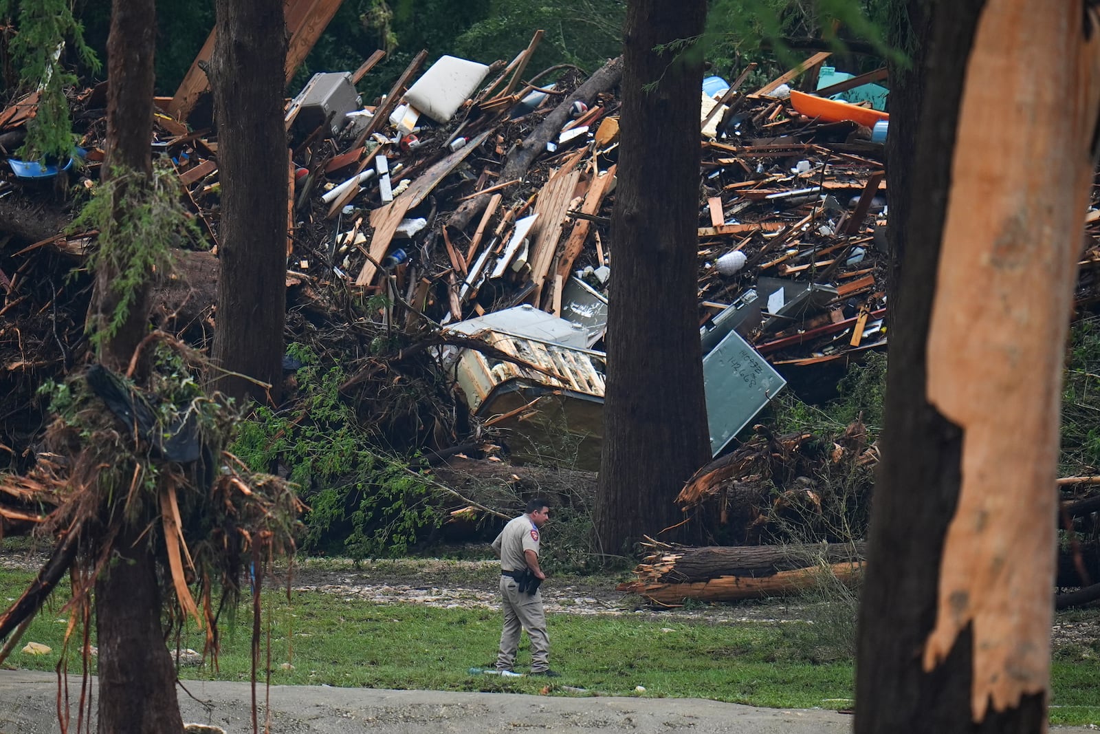 Officials comb through the banks of the Guadalupe River after a flash flood swept through the area Saturday, July 5, 2025, in Hunt, Texas. (AP Photo/Julio Cortez)