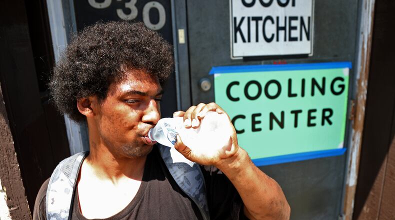 Brandon Clifford chugs a bottle of water he got in the Cooling Center at the Springfield Soup Kitchen Tuesday. As temperatures rose above 90 degrees the Soup Kitchen opened as a cooling center where people can come and get out of the heat and get some water. BILL LACKEY/STAFF