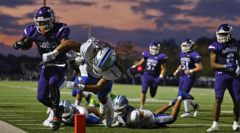 Middletown's Eric Schroeder gets knocked out of bounds by Hamilton's Jailen Morris during their football game Friday, Sept. 29, 2013 at Middletown's Chris Carter Field at Barnitz Stadium. Hamilton won 18-14. NICK GRAHAM/STAFF