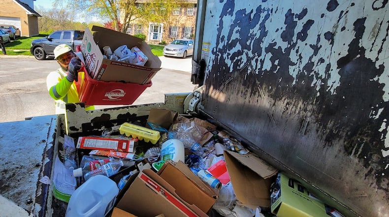 Rumpke employee Michael McDonald collects recyclable materials during his route Friday, April 16, 2021 in West Chester Twp. NICK GRAHAM / STAFF