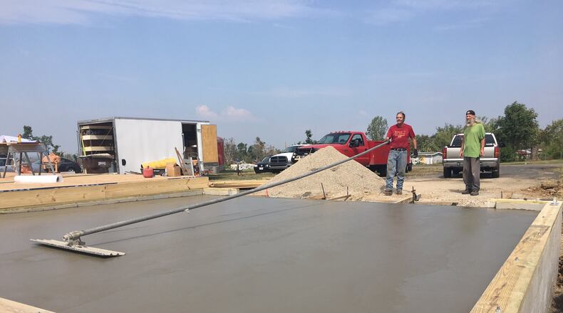 Greg Umstead of Spring Valley puts the finishing touches on a concrete foundation of a detached garage on Rosehill Drive in Beavercreek that was destroyed in the Memorial Day tornado outbreak. RICHARD WILSON/STAFF