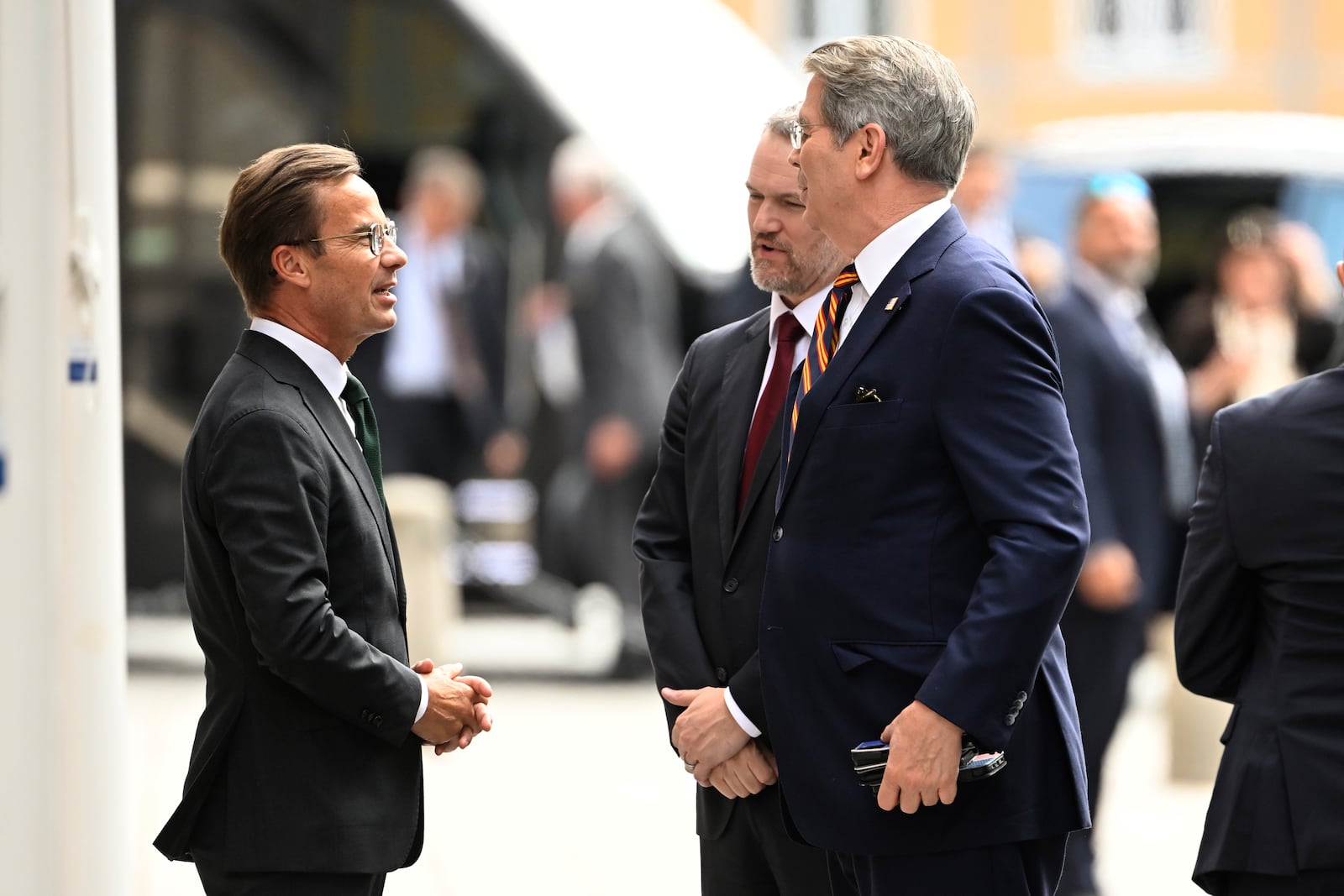 Swedens prime minister Ulf Kristersson, left, greets US treasury secretary Scott Bessent, right, and US trade representative Jamieson Greer, second right, outside Rosenbad ahead of trade talks between the US and China in Stockholm, Sweden, July 28, 2025. (Fredrik Sandberg/TT News Agency via AP)