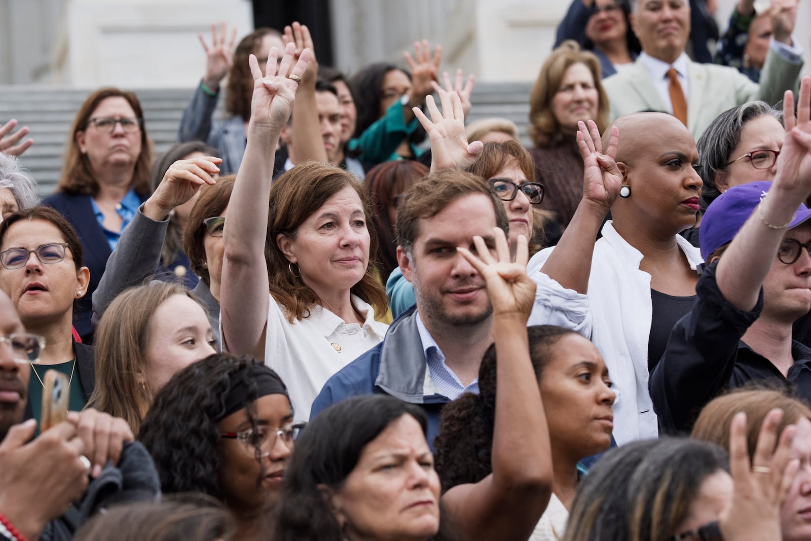 House Democrats on the steps of the Capitol hold up four fingers to signify how many Republicans are needed to vote against President Donald Trump's signature bill of tax breaks and spending cuts, in Washington, Wednesday, July 2, 2025. (AP Photo/J. Scott Applewhite)