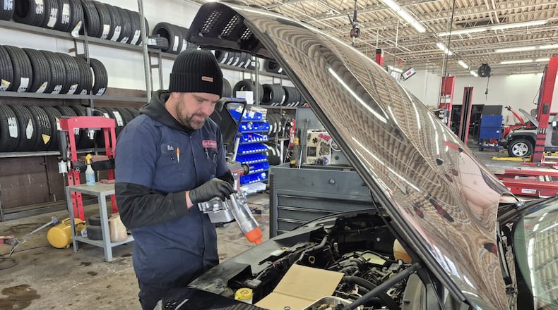 Rick Ahlers, a mechanic at Grismer Tire & Auto Service Center in Springboro, works on a faulty oil pump. Mechanics say storm-related business has been slower than expected. MICHAEL KURTZ / STAFF