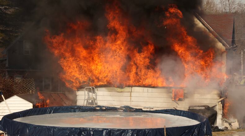 Crews battle a large fire Tuesday, Feb. 15, 2022, involving a detached two-car garage in the 1600 block of Summit Street in Springfield. BILL LACKEY/STAFF