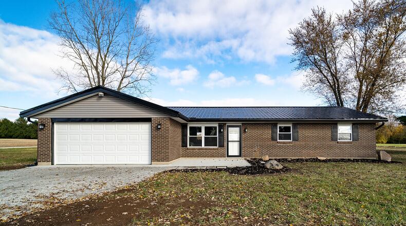 The front of the home features a long gravel driveway, two-car attached garage and oversized concrete front porch. The home has a new metal roof. Contributed photos