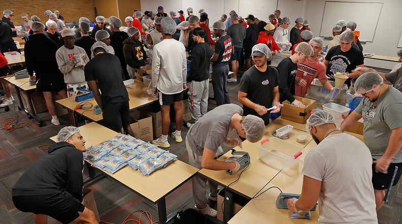 The Wittenberg University football team spent Wednesday afternoon packaging 30,000 nutritious meals to combat childhood malnutrition in the African nation of Lesotho. The meals contain rice and grain along with dehydrated vegetables and nutritional supplements all sealed in a bag. BILL LACKEY/STAFF