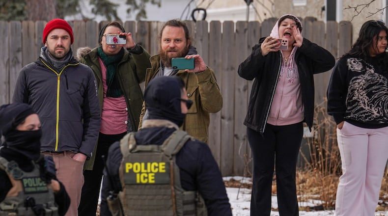 Observers film while federal agents conduct immigration enforcement operations, on Thursday, Feb. 5, 2026, in Minneapolis. (AP Photo/Ryan Murphy)