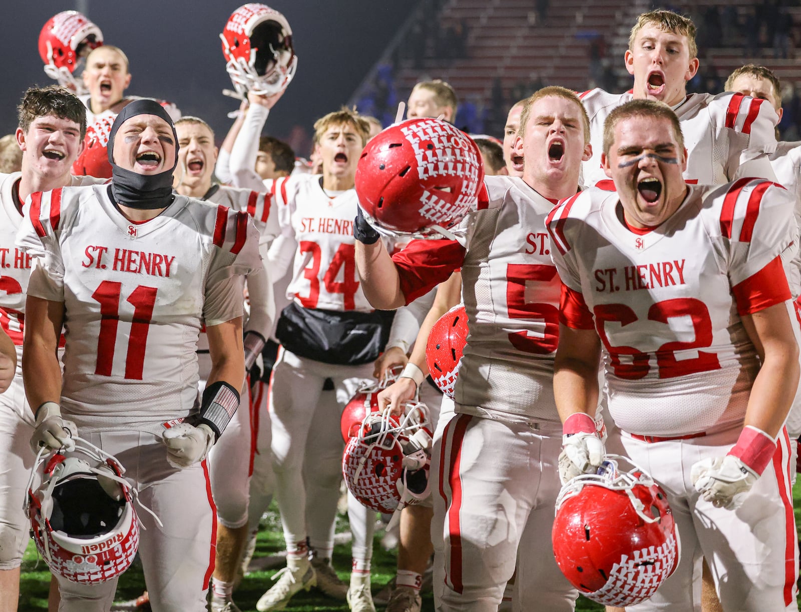 St. Henry players celebrate after defeating Marion Local 24-7 in the Division VII, Region 28 championship on Friday, Nov. 21 at Mercy Health/Wapak VFW Field in Wapakoneta. The Redskins stopped a 76-game winning streak by their Midwest Athletic Conference rival Marion Local. BRYANT BILLING/STAFF