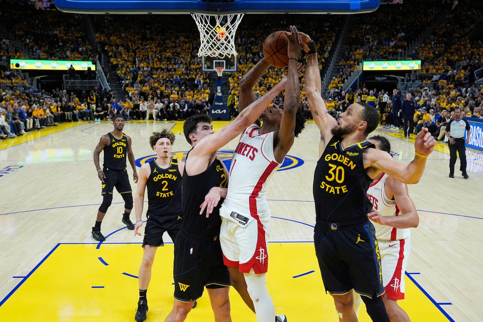 Houston Rockets forward Amen Thompson (1) shoots between Golden State Warriors center Quinten Post (21) and guard Stephen Curry (30) during the second half of Game 6 of an NBA basketball first-round playoff series Friday, May 2, 2025, in San Francisco. (AP Photo/Godofredo A. Vásquez)
