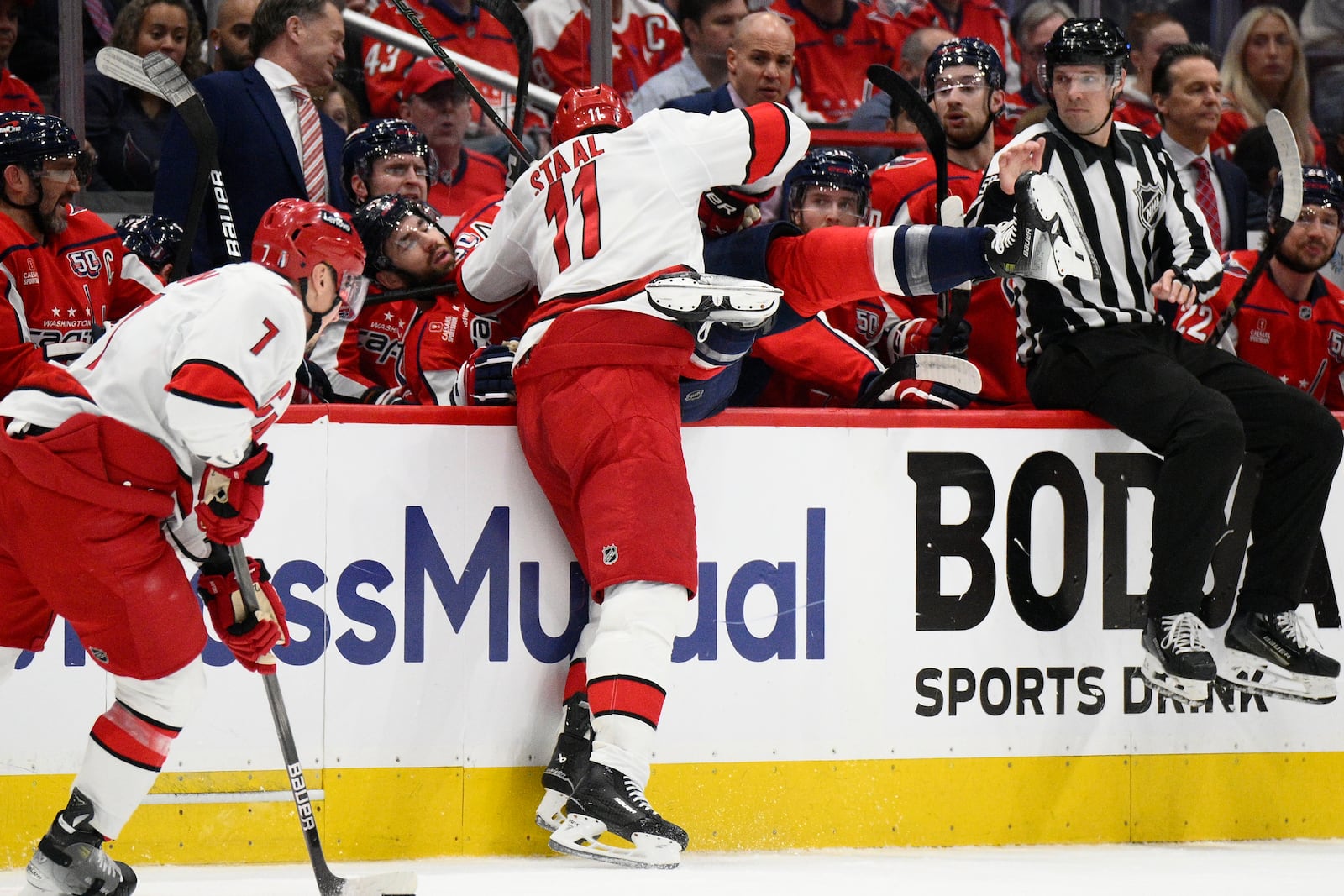 Carolina Hurricanes center Jordan Staal (11) hits Washington Capitals right wing Tom Wilson (43) into the bench area in the first period of Game 2 of a second-round NHL hockey playoff series Thursday, May 8, 2025, in Washington. (AP Photo/Nick Wass)