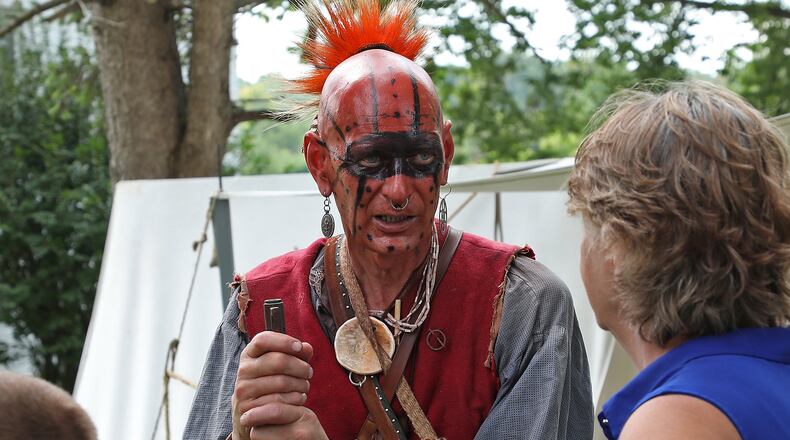 Ralph Arms talks to a family about Native American life at the Fair at New Boston Saturday. BILL LACKEY/STAFF