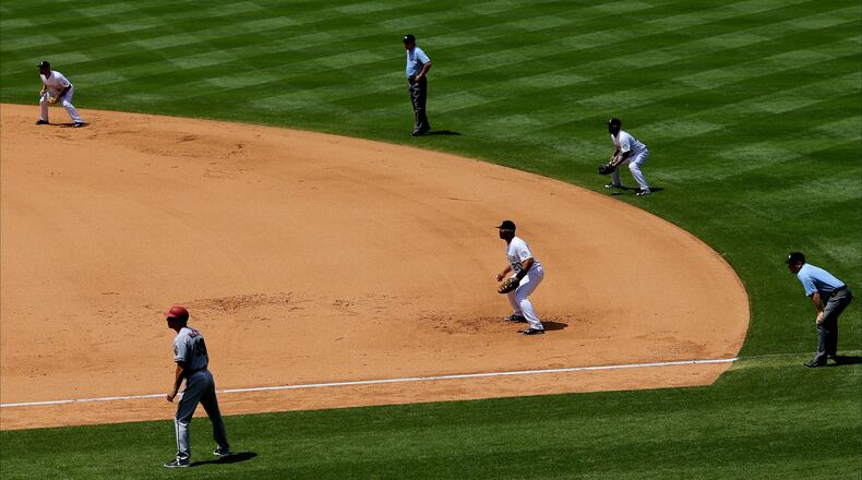 DENVER, CO - JUNE 25: A defensive shift makes for a busy right side of the diamond including (L-R) shortstop Daniel Descalso #3 of the Colorado Rockies, first base coach Dave McKay #39 of the Arizona Diamondbacks, second base umpire Jeff Nelson, first baseman Wilin Rosario #20 of the Colorado Rockies, second baseman Rafael Ynoa #43 and first base umpire Clint Fagan all prepare for the pitch during the sixth inning at Coors Field on June 25, 2015 in Denver, Colorado. The Rockies defeated the Diamondbacks 6-4. (Photo by Justin Edmonds/Getty Images)