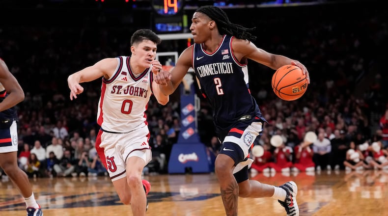 UConn guard Silas Demary Jr. (2) drives past St. John's guard Dylan Darling (0) during the half of an NCAA college basketball game in the championship of the Big East tournament, Saturday, March 14, 2026, in New York. (AP Photo/Yuki Iwamura)