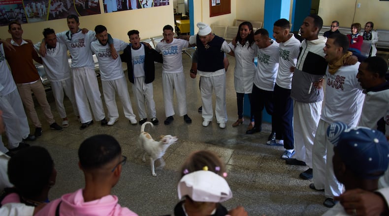 People undergoing rehabilitation hug in a circle at a psychiatric hospital in Havana, Cuba, Wednesday, Feb. 25, 2026. (AP Photo/Ramon Espinosa)