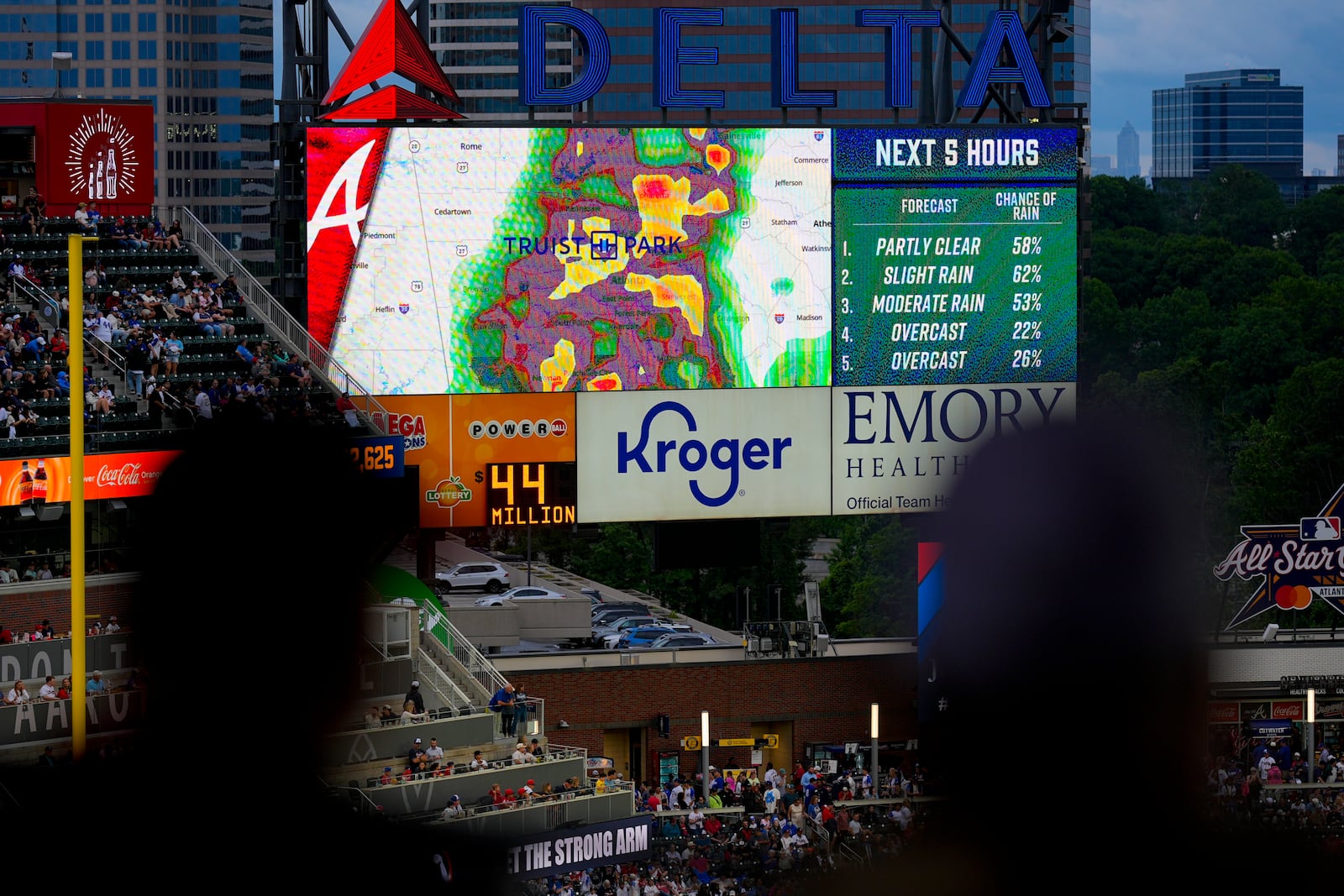 Fans watch the radar displayed before a rain-delayed baseball game between the Atlanta Braves and the Los Angeles Dodgers, Saturday, May 3, 2025, in Atlanta. (AP Photo/Mike Stewart)