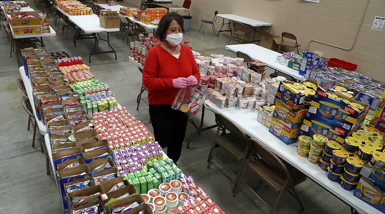 Tecumseh Schools Superintendent Paula Crew was working with other school staff and volunteers to fill food bags for students with the food that was donated by the community. BILL LACKEY/STAFF