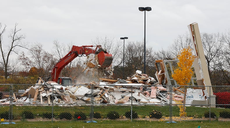 A demolition crew tears down a building in front of the Kohl's department store in the Bechtle Crossing shopping center Tuesday, Nov. 1, 2022. The site will become home to a Panda Express restaurant. BILL LACKEY/STAFF