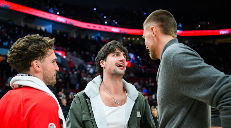 Portland Trail Blazers forward Deni Avdija, center, talks to Atlanta Hawks forwards Corey Kispert, left, and Kristaps Porzingis, right, after an NBA basketball game on Thursday, Jan. 15, 2026, in Portland, Ore. (AP Photo/Molly J. Smith)