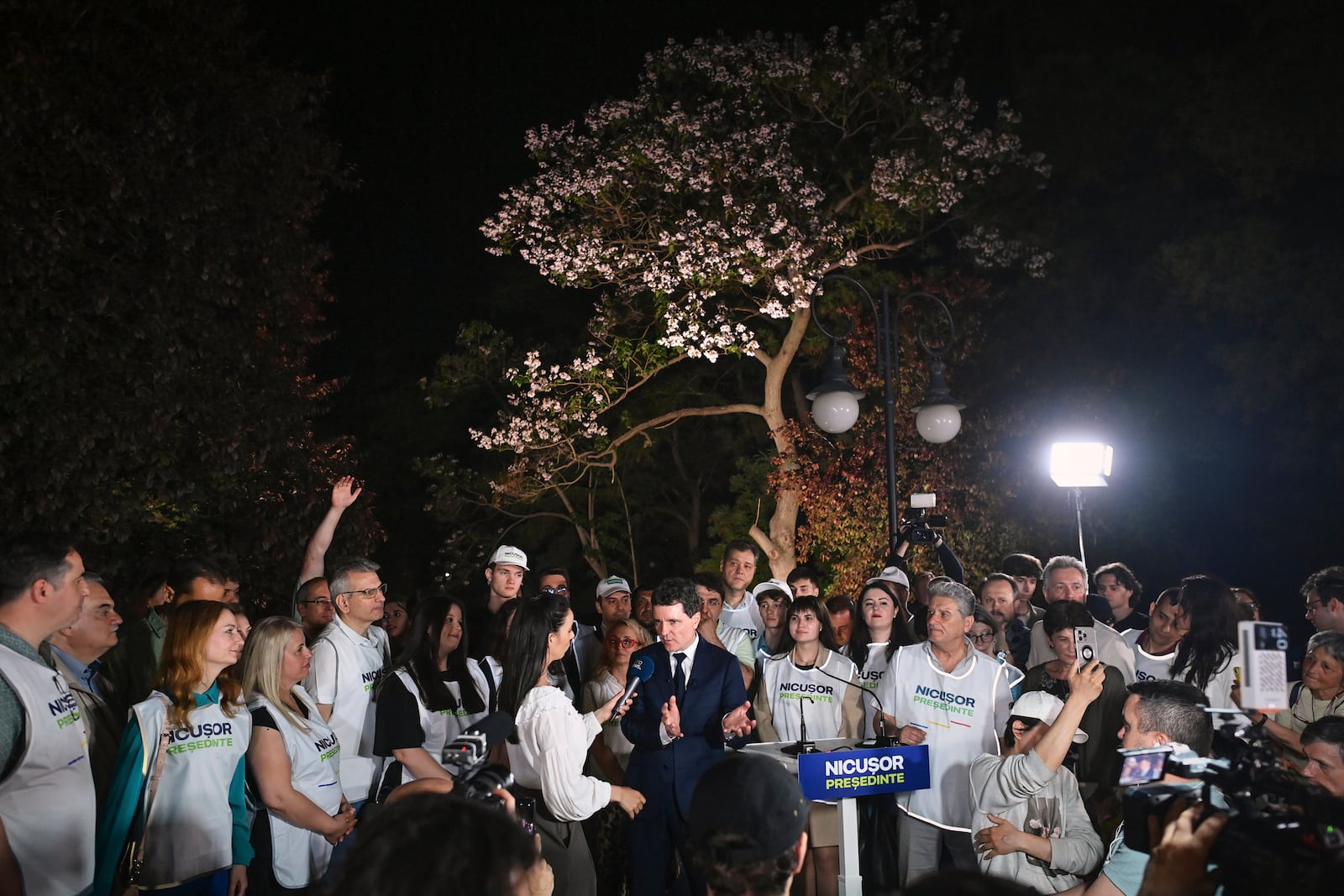 Presidential candidate Nicusor Dan speaks to media, surrounded by supporters, after polls closed in the first round of the country's presidential election redo in Bucharest, Romania, Sunday, May 4, 2025. (AP Photo/Eduard Vinatoru)