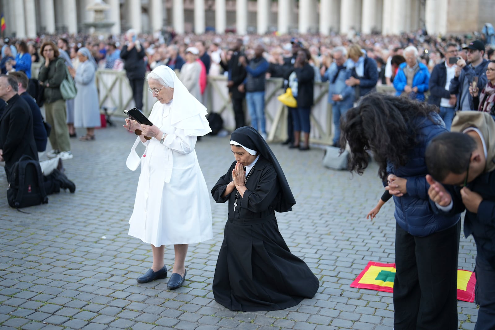 A nun from Peru, center, prays during the speech of the newly elected Pope Leo XIV at the Vatican, Thursday, May 8, 2025. (AP Photo/Francisco Seco)