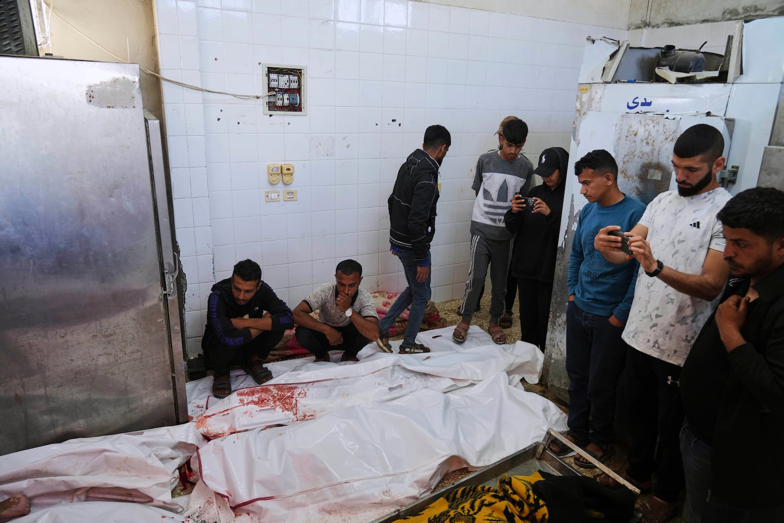 Palestinian mourn their relatives who were killed in an Israeli army airstrike on the Gaza Strip, at the morgue of Al-Aqsa Hospital in Deir al-Balah, Gaza, Thursday, May 22, 2025. (AP Photo/Abdel Kareem Hana)