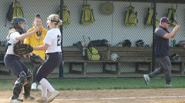 Monroe pitcher Alyssa Wagner (21) is about to hug catcher Sam Schwab as coach J.C. Kellis reacts at the end of a Southwestern Buckeye League Buckeye Division softball game against Brookville. RICK CASSANO/STAFF