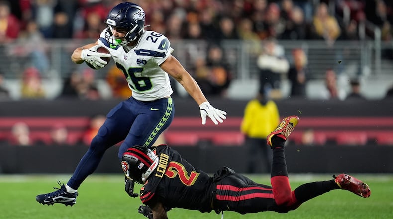 Seattle Seahawks running back Zach Charbonnet (26) runs against San Francisco 49ers cornerback Deommodore Lenoir (2) during the second half of an NFL football game in Santa Clara, Calif., Saturday, Jan. 3, 2026. (AP Photo/Godofredo A. Vásquez)