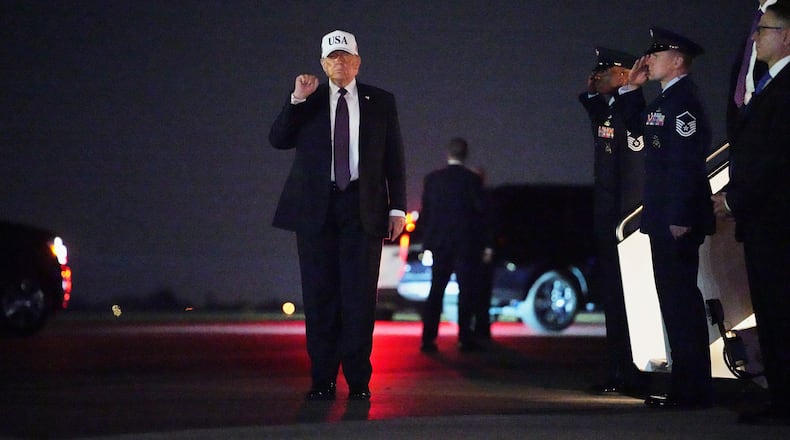President Donald Trump holds up a fist after disembarking Air Force One at Palm Beach International Airport in West Palm Beach, Fla., Friday, Feb. 27, 2026. (AP Photo/Matt Rourke)