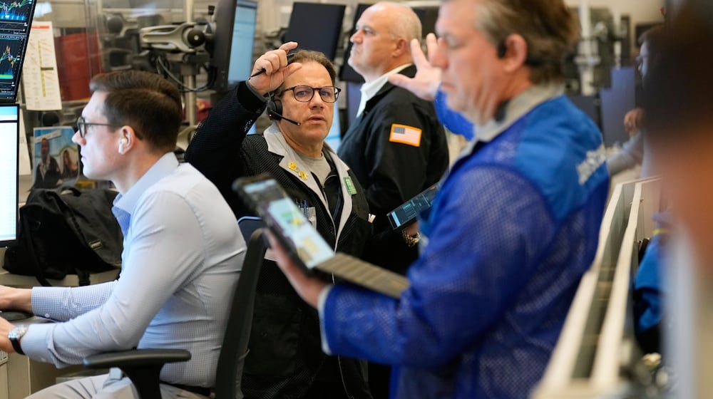 Anthony Spina, center, works on the floor at the New York Stock Exchange in New York, Wednesday, Dec. 10, 2025. (AP Photo/Seth Wenig)