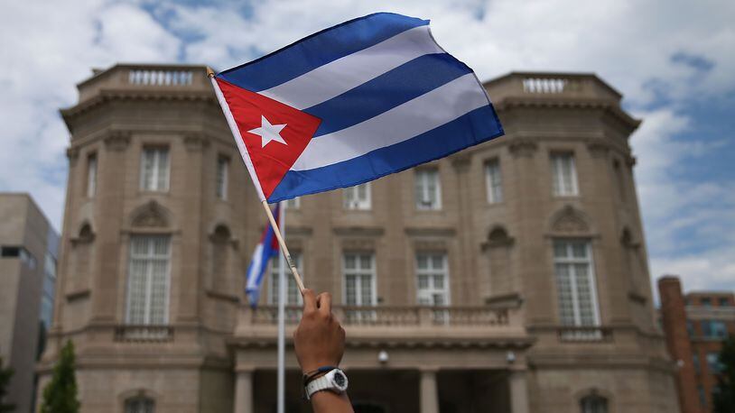 WASHINGTON, DC - JULY 20: A supporter waves a Cuban flag in front of the country's embassy after it re-opened for the first time in 54 years July 20, 2015 in Washington, DC. The embassy was closed in 1961 when U.S. President Dwight Eisenhower severed diplomatic ties with the island nation after Fidel Castro took power in a Communist revolution. (Photo by Mark Wilson/Getty Images)