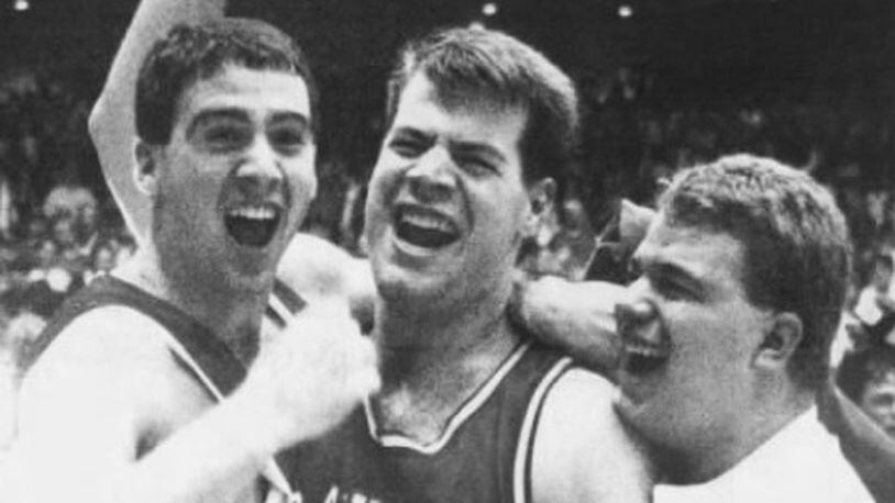 Dayton's Sam Howard, center, celebrates with two fans after a victory against Xavier in the MCC tournament final at UD Arena on March 10, 1990.