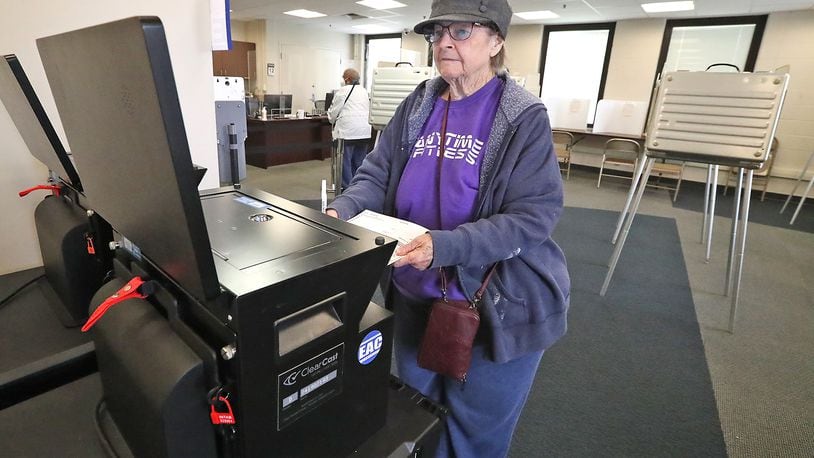 Joy Wohlwend slides her ballot into the voting machine at the Clark County Board of Elections Wednesday, Oct. 12, 2022 during the first day of early voting. BILL LACKEY/STAFF