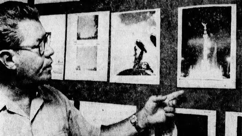 Lt. Col. Hector Quintanella looks at photos of so-called UFOs displayed in the Project Blue Book office at Wright-Patterson Air Force Base in 1968. DAYTON DAILY NEWS ARCHIVES