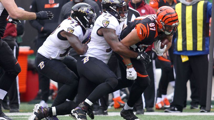 CINCINNATI, OH - JANUARY 1: C.J. Uzomah #87 of the Cincinnati Bengals is tackled by C.J. Mosley #57 of the Baltimore Ravens and Terrell Suggs #55 of the Baltimore Ravensk during the first quarter at Paul Brown Stadium on January 1, 2017 in Cincinnati, Ohio. (Photo by John Grieshop/Getty Images)