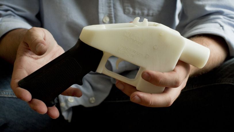 Cody Wilson holds what he calls a Liberator pistol that was completely made on a 3-D-printer at his home in Austin, Texas. Eight states filed suit Monday, July 30, 2018, against the Trump administration over its decision to allow a Texas company to publish downloadable blueprints for a 3D-printed gun, contending the hard-to-trace plastic weapons are a boon to terrorists and criminals and threaten public safety. (Jay Janner/Austin American-Statesman via AP, File)